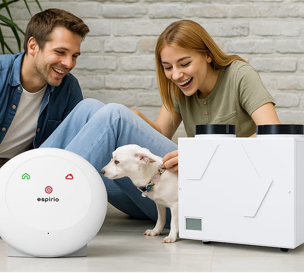 Uśmiechnięta para z psem, obok nich dwa nowoczesne urządzenia do wentylacji lub oczyszczania powietrza marki espirio.